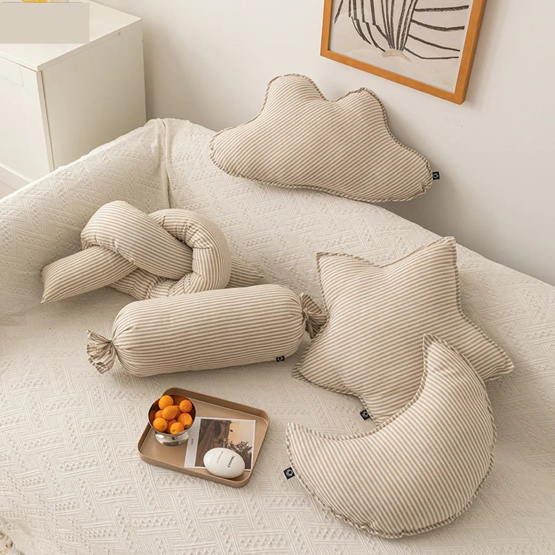 Cloud, star and moon cushions on a bed