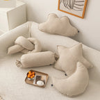Cloud, star and moon cushions on a bed