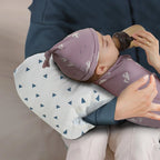 Parent using the nursing arm pillow to support baby during feeding